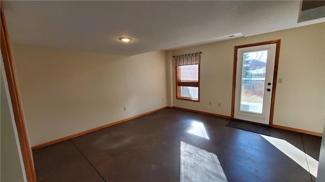 empty room featuring finished concrete flooring and baseboards