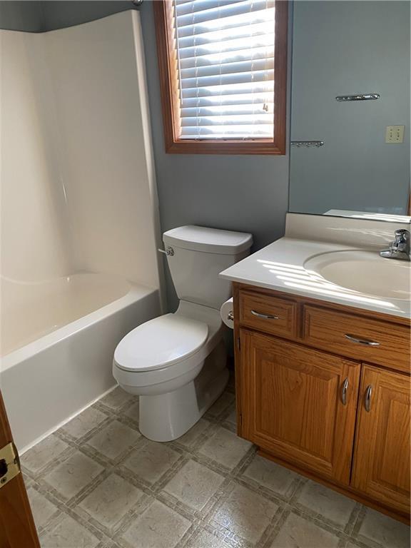 full bath featuring tile patterned floors, shower / bathtub combination, toilet, and vanity