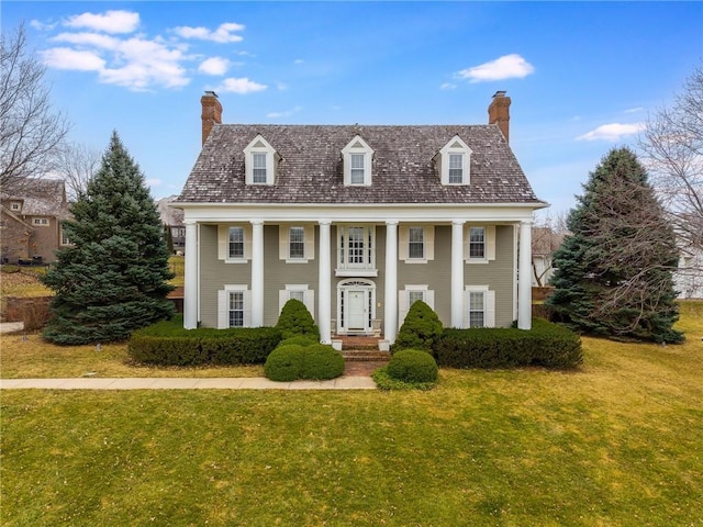 greek revival house with a chimney and a front yard