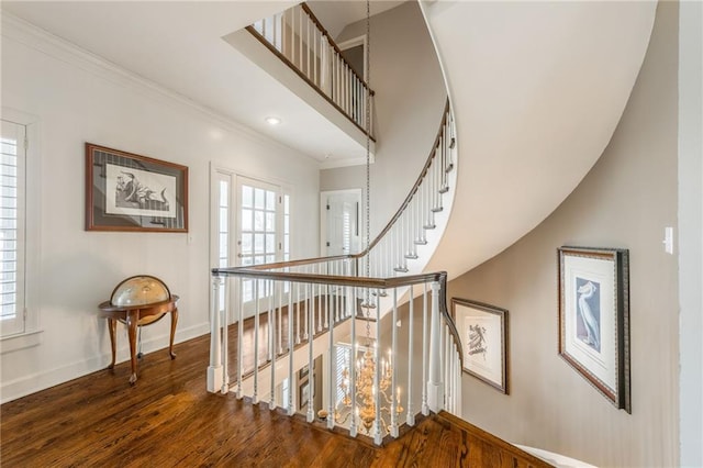 stairs with wood finished floors, baseboards, a high ceiling, french doors, and crown molding