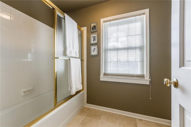 bathroom with baseboards and bath / shower combo with glass door