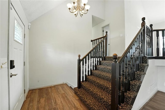 906 N Cedarcrest Dr, Olathe, KS 66061 - foyer entrance featuring wood finished floors, a chandelier, high vaulted ceiling, and stairway