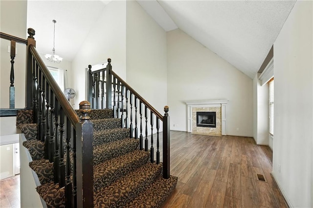 906 N Cedarcrest Dr, Olathe, KS 66061 - stairs featuring a chandelier, wood finished floors, a fireplace, and high vaulted ceiling