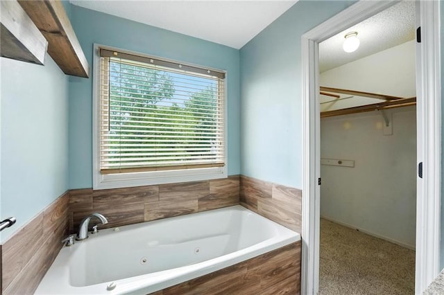 906 N Cedarcrest Dr, Olathe, KS 66061 - bathroom featuring a walk in closet and a jetted tub