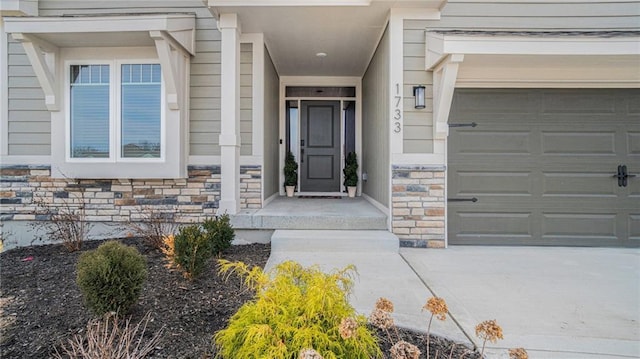 property entrance featuring a garage and stone siding