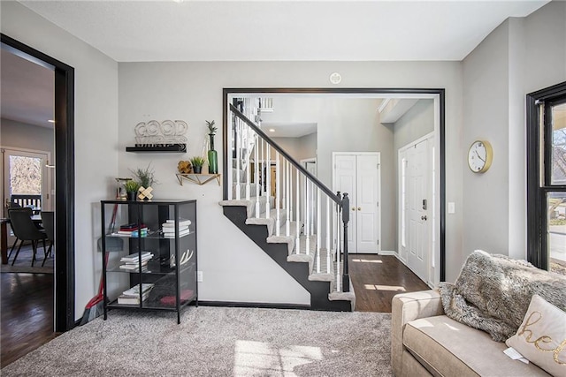 entryway with stairs, baseboards, and wood finished floors