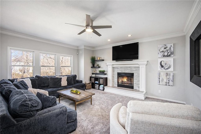 living area featuring ornamental molding, a glass covered fireplace, carpet, baseboards, and ceiling fan