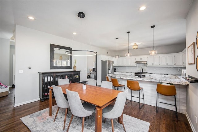 dining area featuring dark wood finished floors, recessed lighting, and baseboards