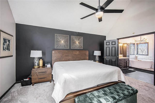 bedroom with an accent wall, baseboards, carpet, high vaulted ceiling, and ensuite bath