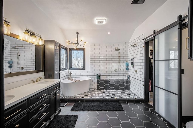 full bathroom featuring double vanity, an inviting chandelier, a tile shower, a sink, and a freestanding bath