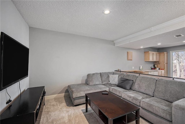 living area with visible vents, baseboards, light carpet, recessed lighting, and a textured ceiling