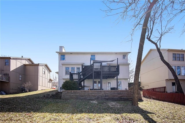 rear view of house with a chimney, stairs, and a deck