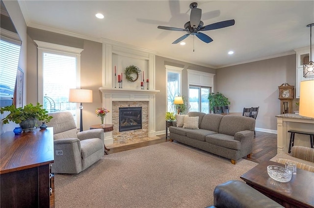 living room with wood finished floors, ornamental molding, and a fireplace with flush hearth