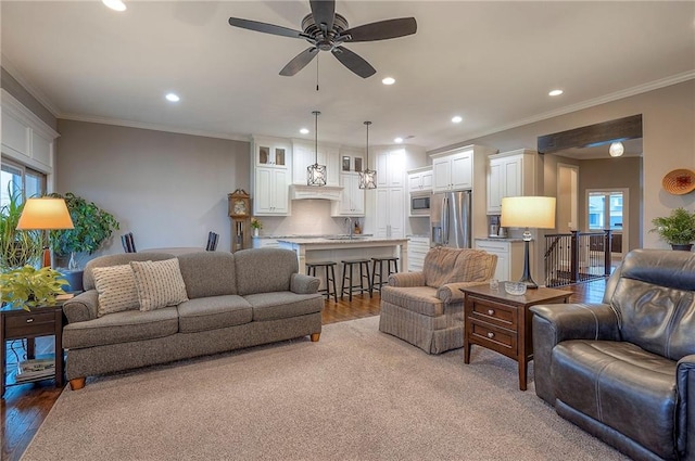 living area featuring ornamental molding, wood finished floors, and recessed lighting