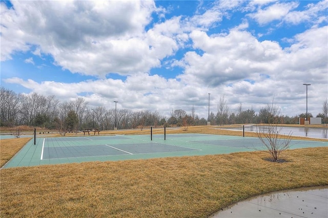 view of tennis court featuring a yard