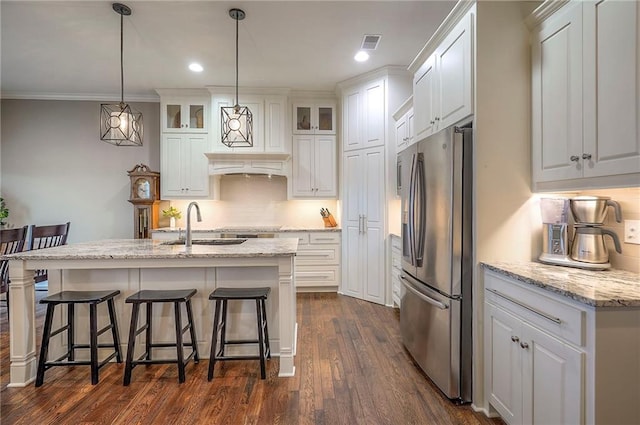 kitchen with white cabinets, stainless steel fridge, decorative backsplash, and dark wood finished floors