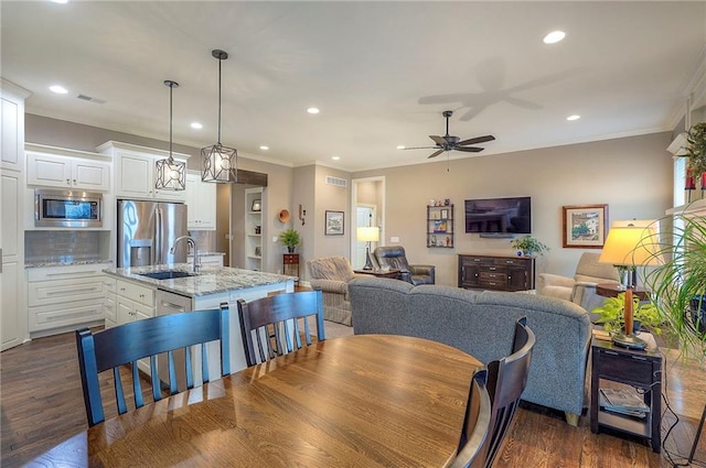 dining area with dark wood-type flooring, recessed lighting, and ornamental molding