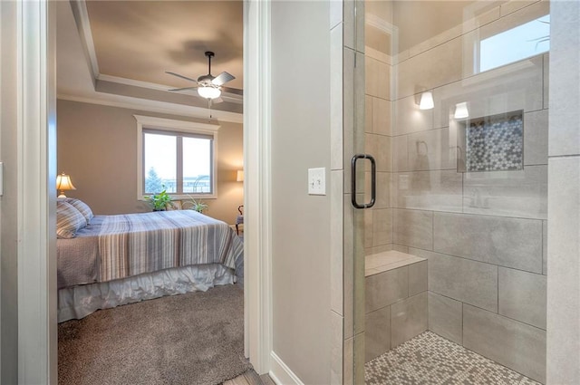 ensuite bathroom featuring a raised ceiling, ornamental molding, a ceiling fan, a shower stall, and ensuite bath