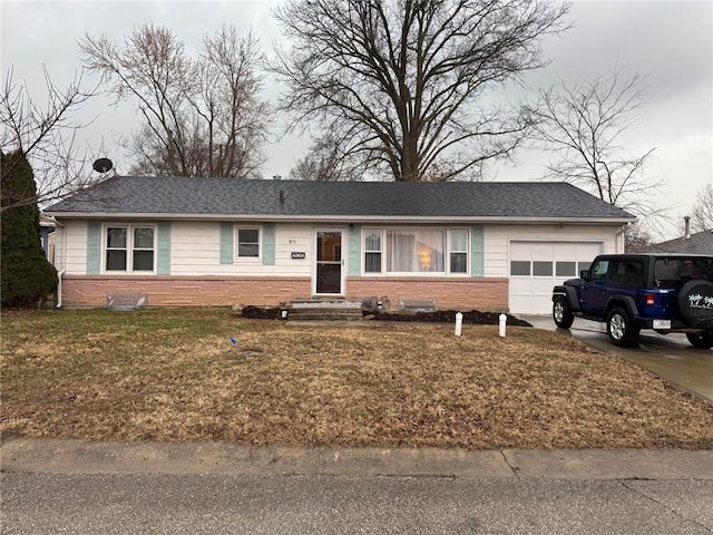 single story home with a garage, a front yard, brick siding, and driveway