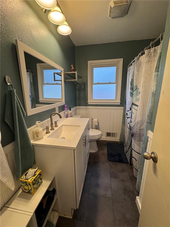 full bathroom with wainscoting, visible vents, toilet, and vanity