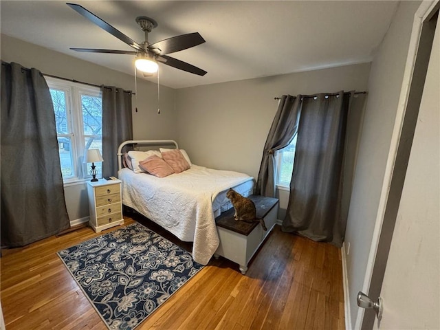 bedroom featuring hardwood / wood-style flooring, ceiling fan, and baseboards