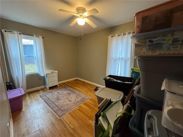 interior space featuring ceiling fan, hardwood / wood-style flooring, and baseboards