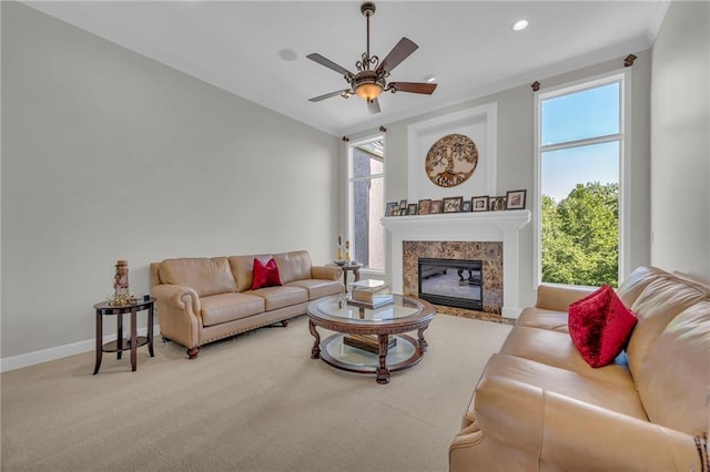 living area featuring recessed lighting, a premium fireplace, carpet flooring, a ceiling fan, and baseboards