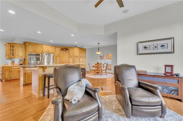 living area featuring light wood-type flooring, ceiling fan, crown molding, and recessed lighting