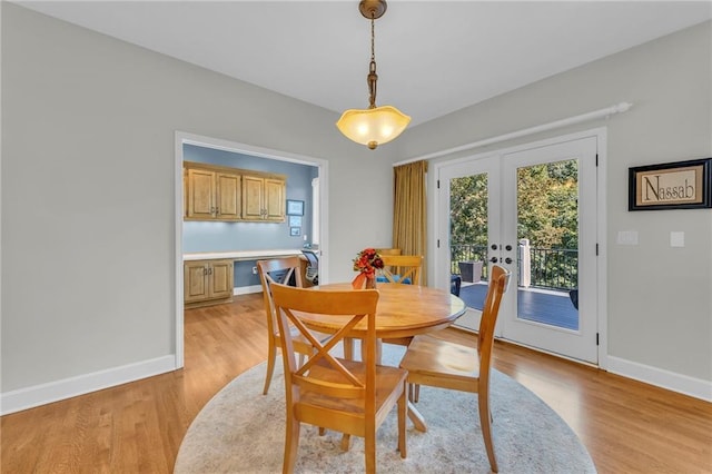 dining room featuring french doors, light wood-type flooring, and baseboards