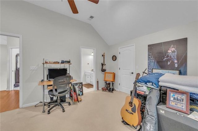 carpeted home office with visible vents, vaulted ceiling, and a ceiling fan