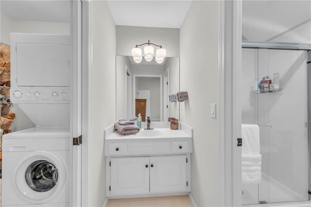 bathroom with a stall shower, stacked washer / dryer, and vanity