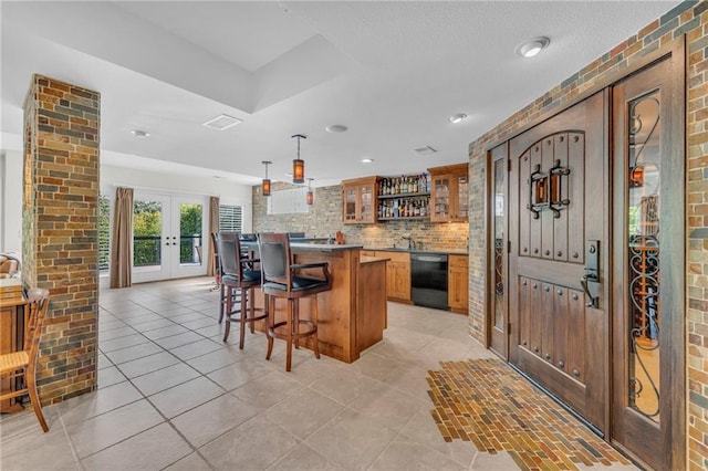 bar with light tile patterned floors, dishwasher, backsplash, french doors, and indoor wet bar