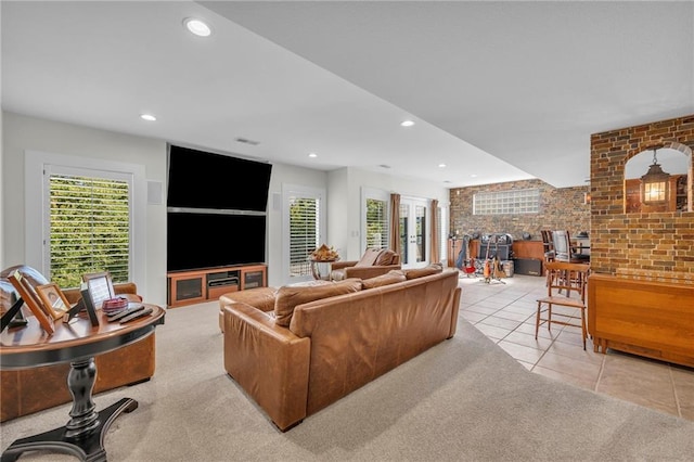 tiled living room with recessed lighting and brick wall