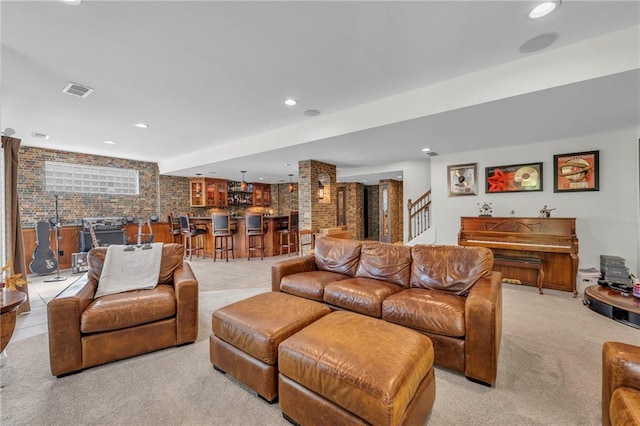 living area with recessed lighting, light carpet, brick wall, wet bar, and stairs