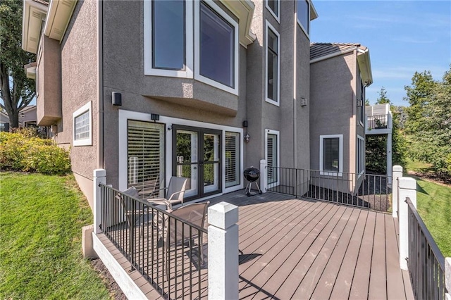 rear view of property featuring a lawn and stucco siding