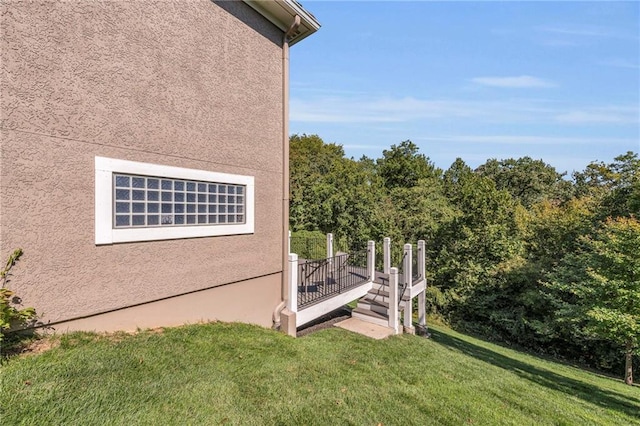 view of side of property featuring a lawn and stucco siding