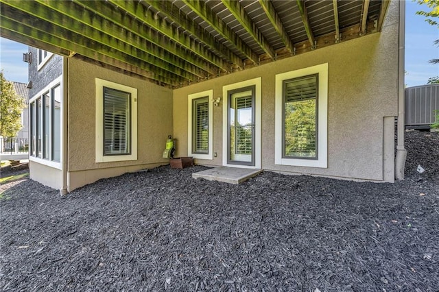 exterior space with central AC unit and stucco siding