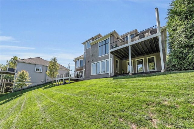 rear view of property with a lawn and stucco siding