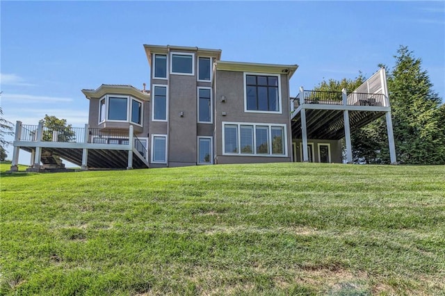 back of house with a yard, stucco siding, and a wooden deck