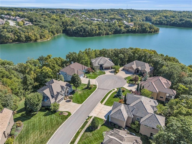 drone / aerial view with a forest view, a water view, and a residential view