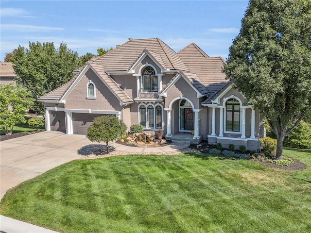 view of front of house with a garage, concrete driveway, a front lawn, and stucco siding