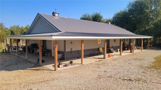 back of house featuring a patio area and metal roof