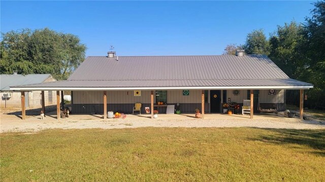 1147 Fern Rd, Fort Scott, KS 66701 - back of property featuring a yard, metal roof, a chimney, and a patio area