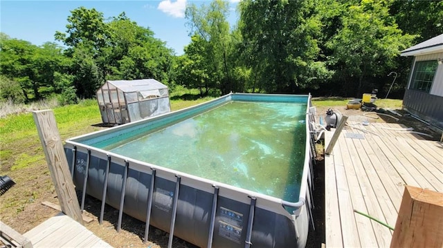 1147 Fern Rd, Fort Scott, KS 66701 - view of swimming pool with a deck, an outbuilding, and a greenhouse