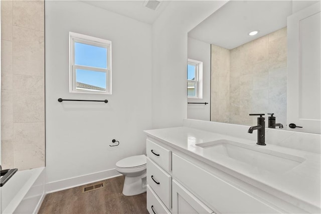 full bath with toilet, plenty of natural light, baseboards, and wood finished floors