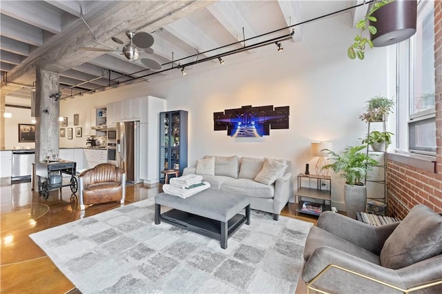 living area featuring brick wall and track lighting