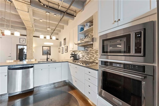 kitchen featuring stainless steel appliances, a sink, white cabinetry, range hood, and decorative backsplash