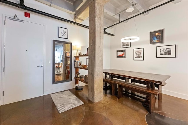 dining room featuring finished concrete flooring and baseboards