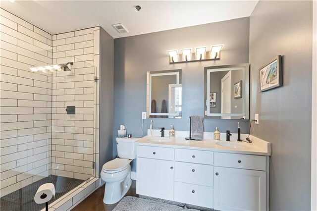 full bath with visible vents, a sink, a shower stall, and toilet