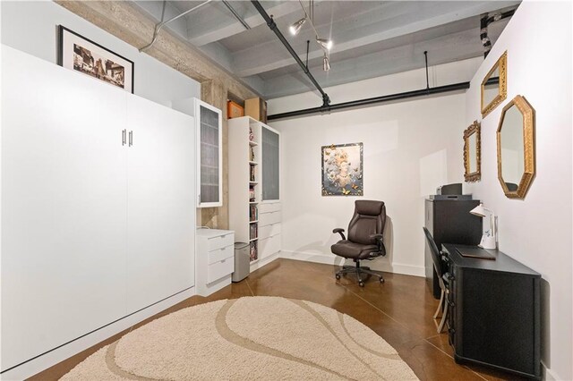 sitting room with concrete flooring, a garage, and baseboards